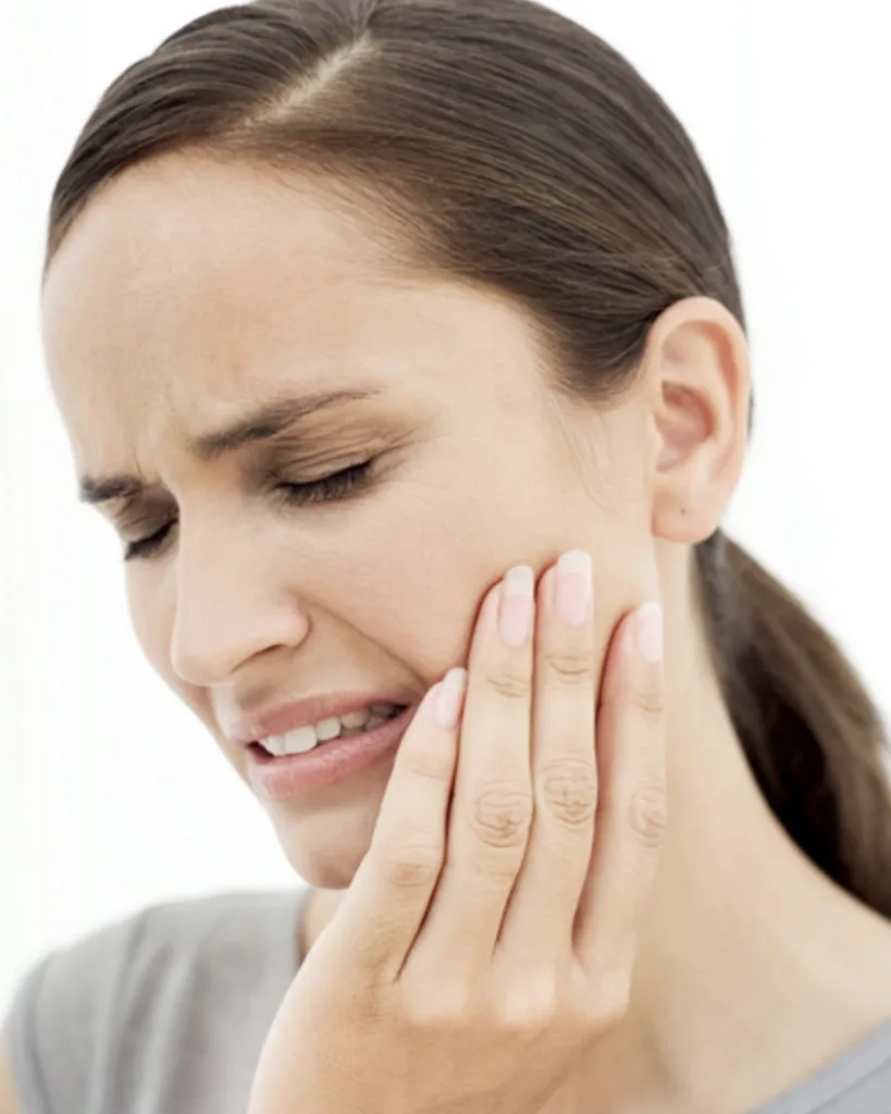 woman in pain from tooth implant - Dentaluxe