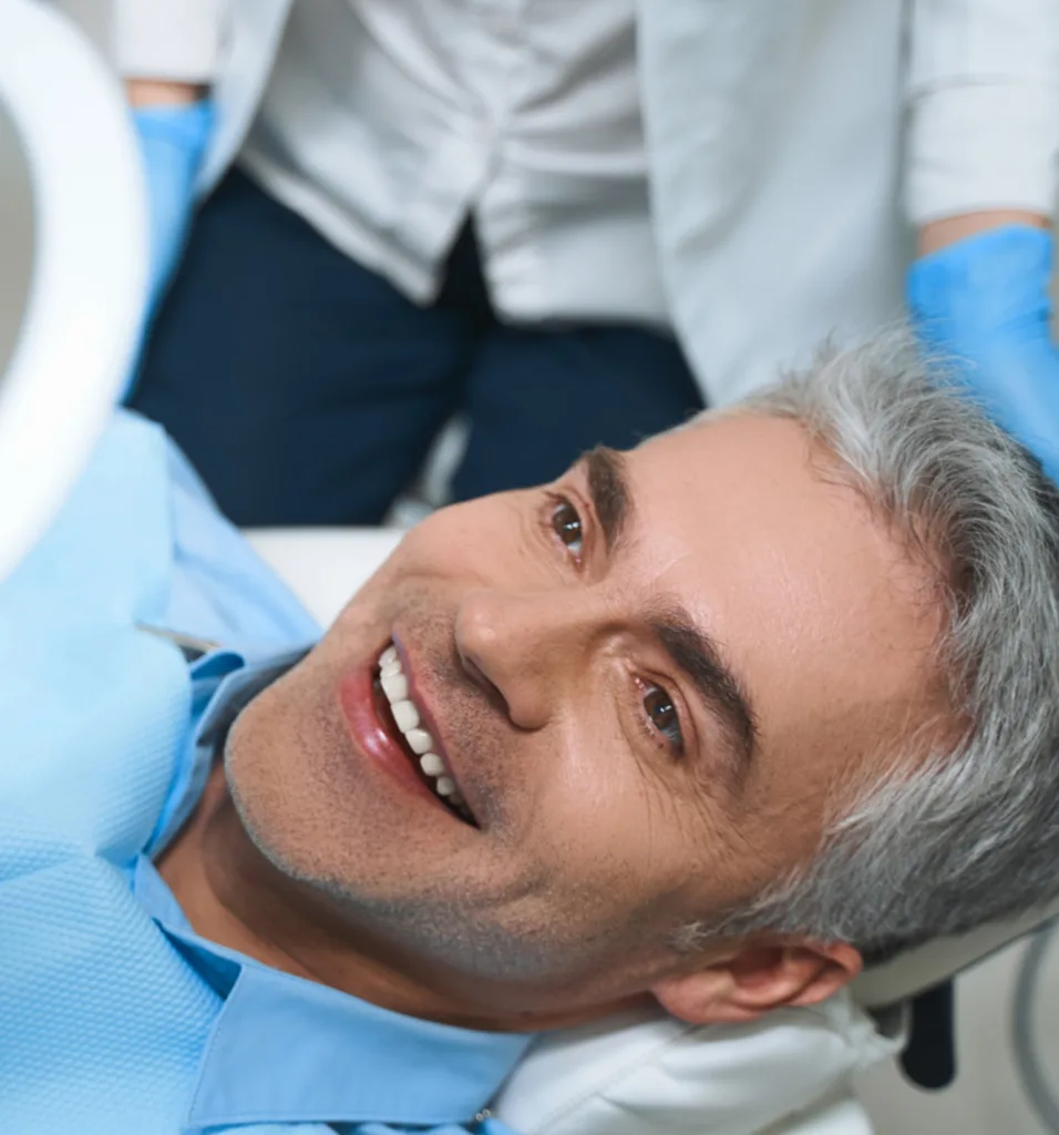 man in exam chair smiling - Dentaluxe