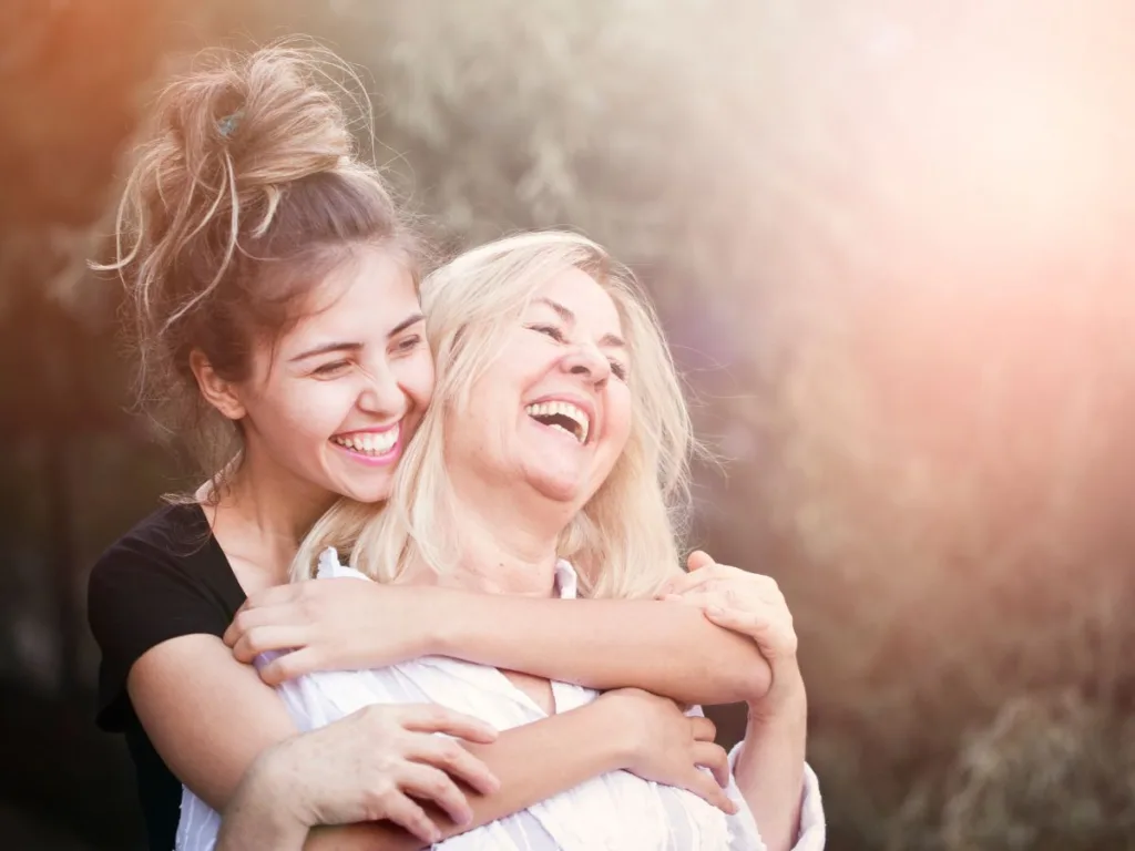 daughter hugs mother and talks Benefits of tooth implants